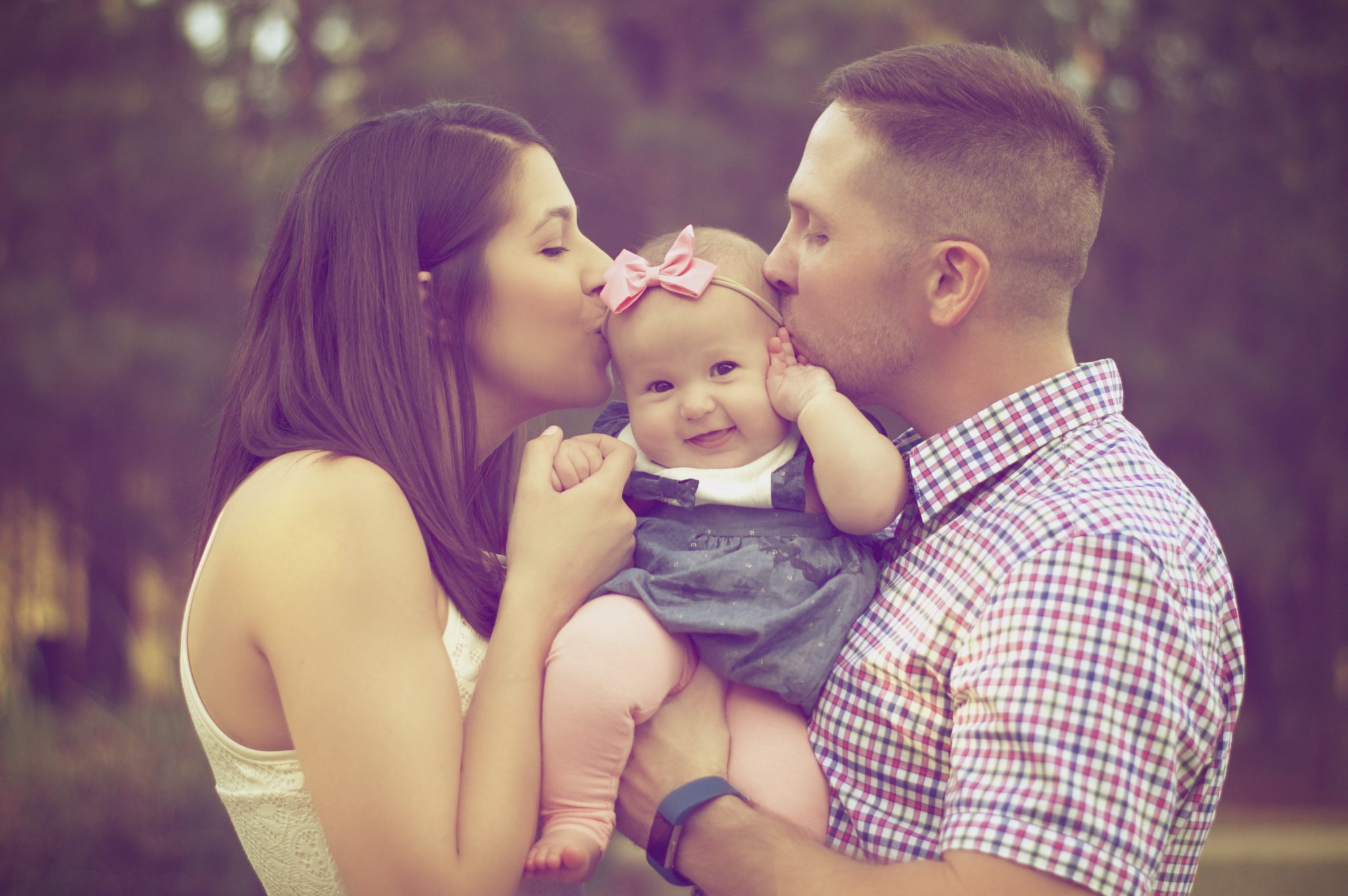 Parents kissing child