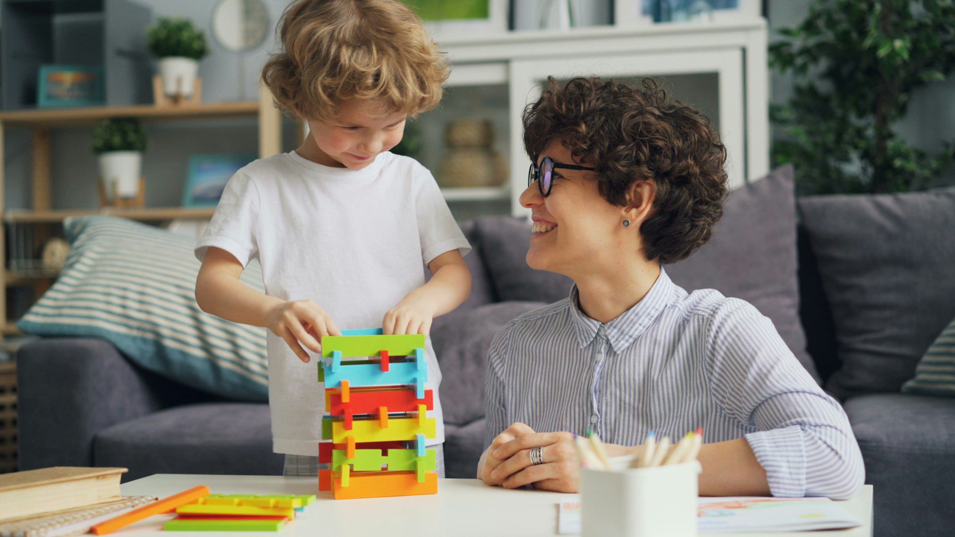 Parent and child playing through a routine with building toys